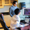 Photo of Zhe Zhu and graduate student working in the lab